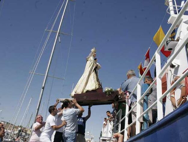 Momento del embarque de la talla de la Virgen en una de las embarcaciones portuenses./Andr&eacute;s Mora