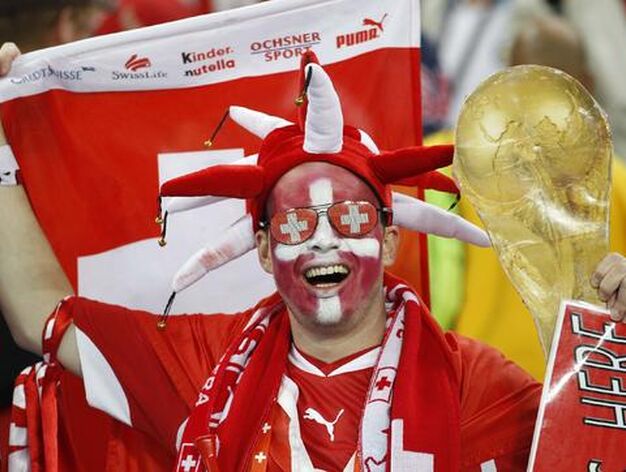Un aficionado suizo, con los colores de su pa&iacute;s y una r&eacute;plica de la copa del mundo. / Reportaje gr&aacute;fico: EFE, Reuters, AFP