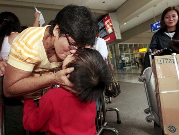 Una mujer filipina saluda a sus familiares a su llegada de Jap&oacute;n.