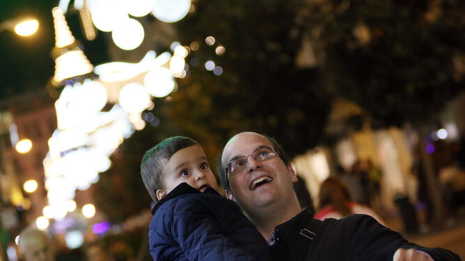 Un padre muestra a su hijo el alumbrado navideño en el Centro.