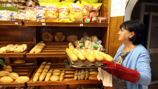 Chelo Castillejo coloca el pan recién horneado en la Cafetería Doce de Octubre.