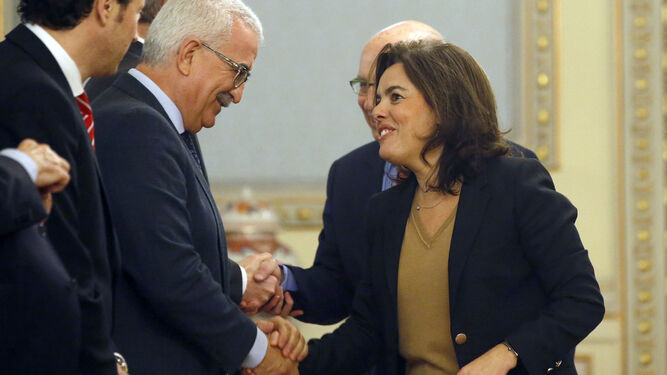 Manuel Jiménez Barrios y Soraya Sáenz de Santamaría se saludan ayer en una reunión en Madrid.