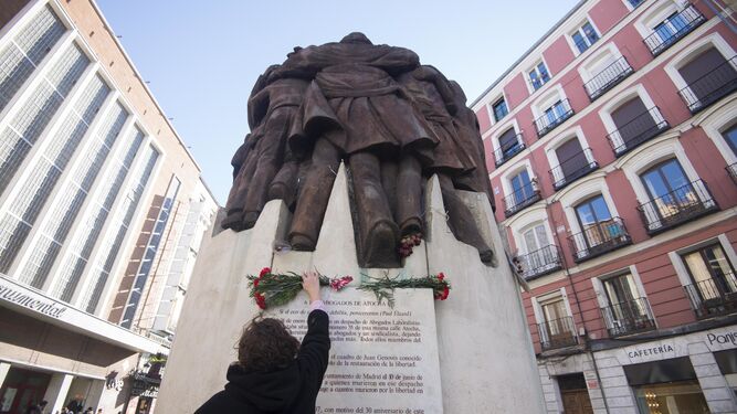 Una mujer colocaba el jueves un ramo de flores en el monumento al crimen de Atocha que esculpió Juan Genovés.