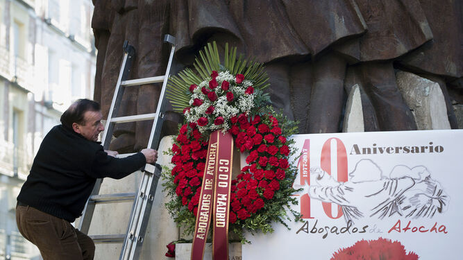 Un hombre coloca un ramo de flores en el monumento a los abogados.