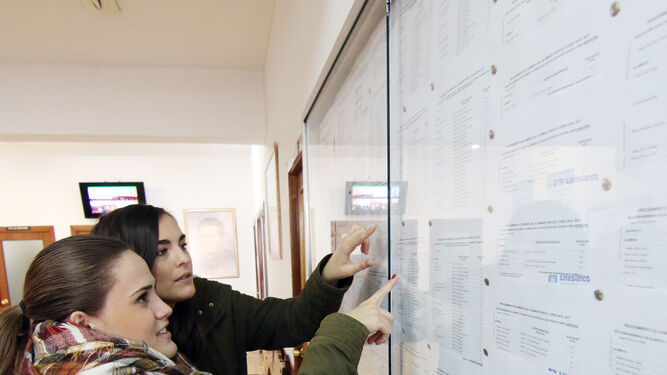 Dos mujeres observan las listas baremadas de un colegio.