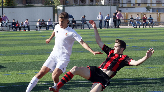 Un jugador del Séneca intenta arrebatar el esférico a uno del Sevilla.