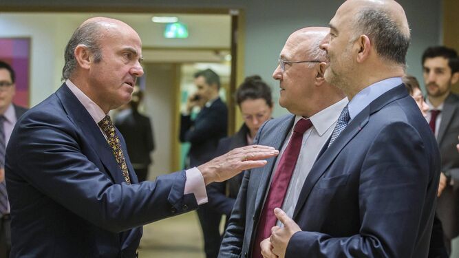 De Guindos, que fue candidato a presidir el Eurogrupo, conversa con Moscovici y el ministro francés Michel Sapin.
