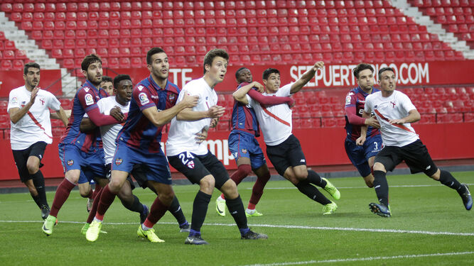 Los sevillistas Bernardo, Yan Brice y Marc Gual buscan el remate en una acción a balón parado ante el Levante.