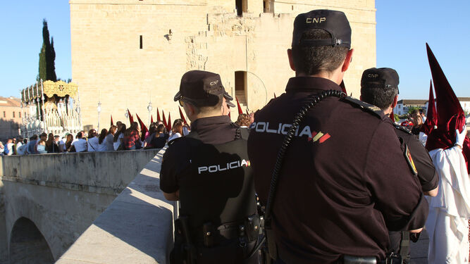 La Virgen de la cofradía de la Vera-Cruz accede a un Puente Romano vigilado por la Policía Nacional.