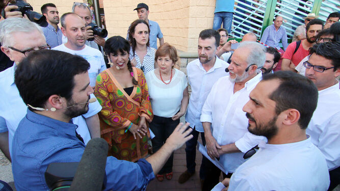 El líder de IU, Alberto Garzón, habla con Julio Anguila y Pedro García en presencia de Teresa Rodríguez en la presentación de Unidos Podemos.