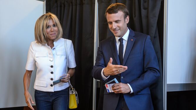 Emmanuel Macron da paso ayer a su esposa, Brigitte Trogneux, para votar tras introducir la papeleta en el sobre.