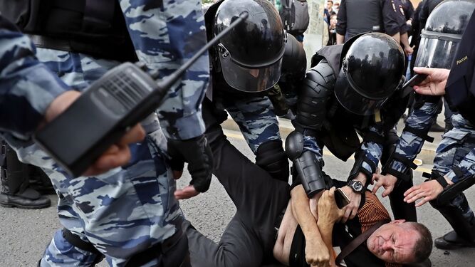 Los policías reducen a un manifestante.