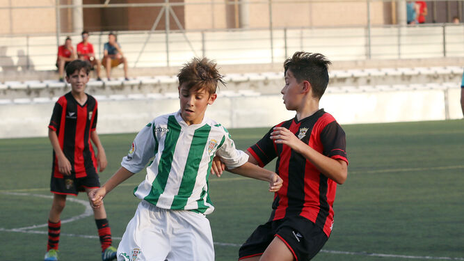 Un jugador del Córdoba alevín escapa con el balón eludiendo la presión de un jugador del Séneca.