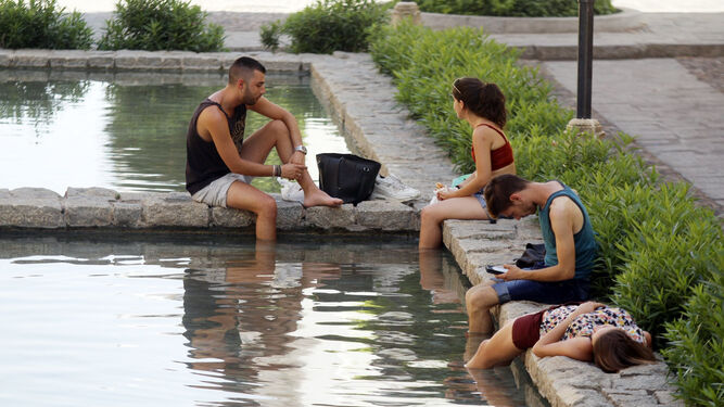 Unos jóvenes se refrescan en una de las fuentes  del centro de Córdoba.