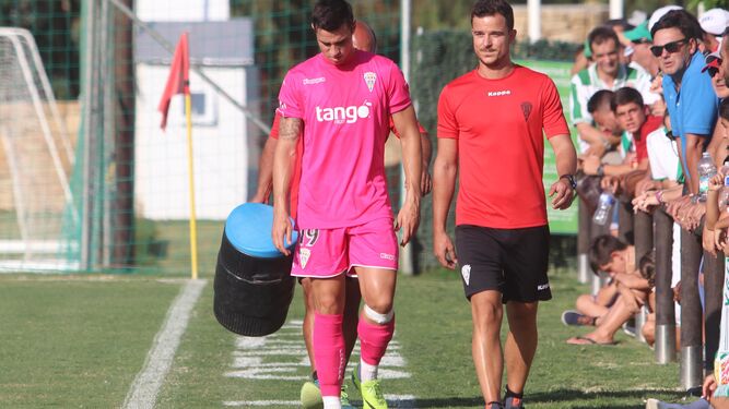 Jaime Romero se retira en compañía del recuperador José Roca tras caer lesionado en el partido ante el Almería del pasado sábado.