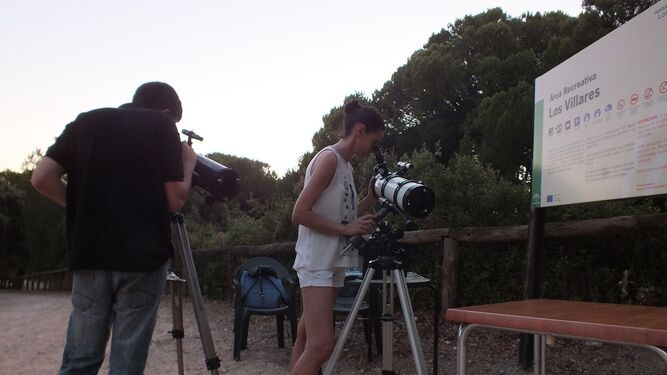 Dos participantes de las actividades manipulan telescopios en Los Villares.