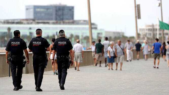Tres mossos vigilan una playa de Barcelona después de los atentados.