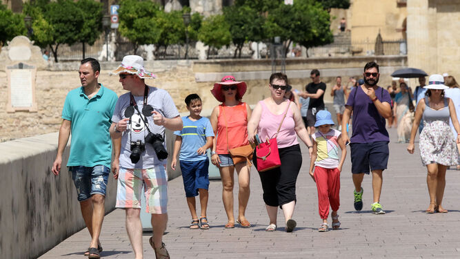 Un grupo de turistas atraviesa el Puente Romano.