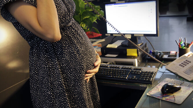 Mujer embarazada  en su puesto de trabajo.