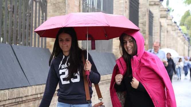 Dos jóvenes se resguardan de la lluvia