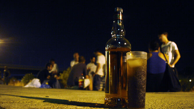 Varios jóvenes beben en una 'botellona' junto al río Guadalquivir.