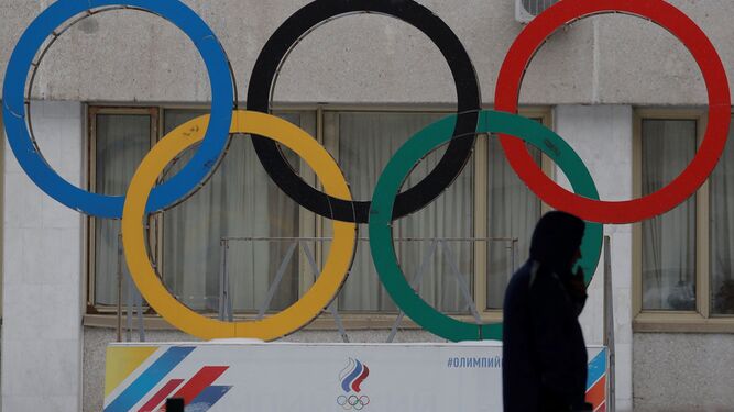 Un hombre pasa delante de los anillos olímpicos que decoran el acceso a la sede del Comité Olímpico ruso en Moscú (Rusia).