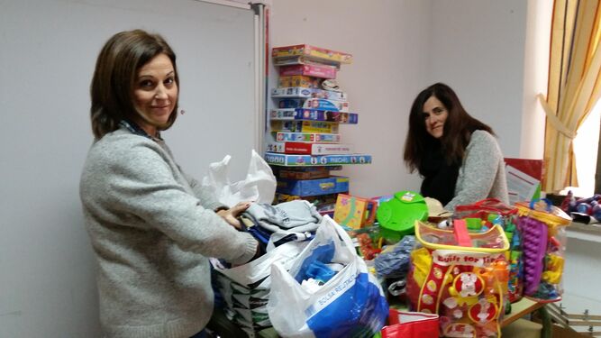Integrantes de la asociación de padres y madres del colegio La Aduana ordenan bolsas con juguetes.