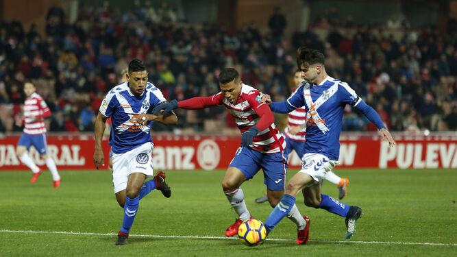 Dos jugadores del Tenerife tratan de frenar a Machís (Granada).