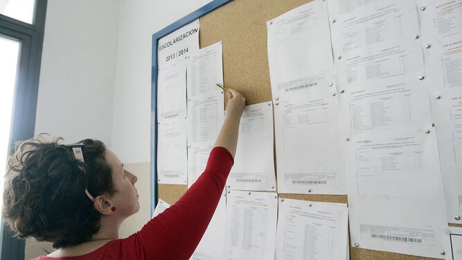 Una mujer observa las listas de baremación de un colegio de la capital.