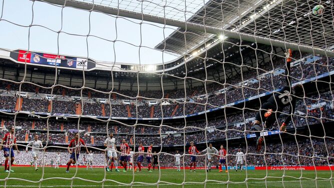 El portero del Atlético, Jan Oblak, desvía a córner una falta directa botada por Sergio Ramos al final del derbi en el Bernabéu.