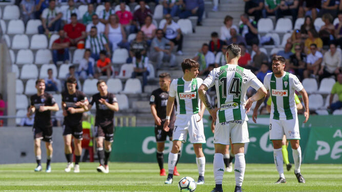 Aythami trata de animar a sus compañeros, mientras Guardiola y Álvaro Aguado se disponen a sacar de centro tras un gol del Huesca.