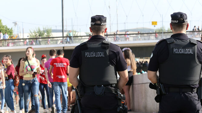 Dos agentes de la Policía Local realizan labores de seguridad en el botellón clásico de los miércoles de Feria.