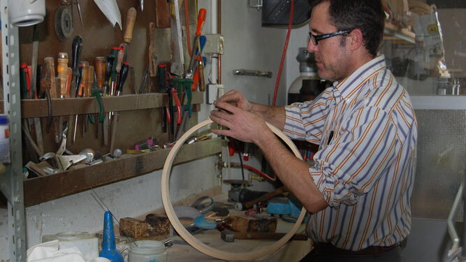 Un artesano con el aro de un tambor.