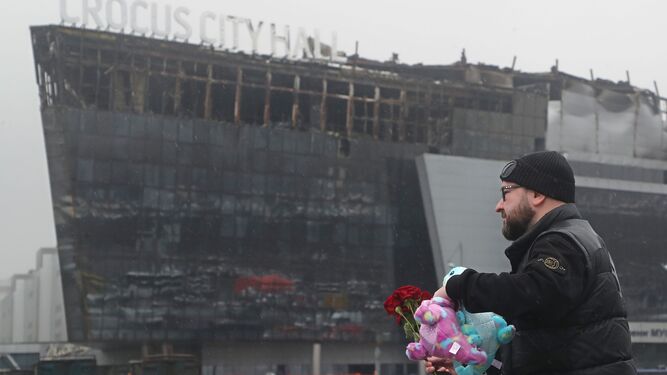 Un hombre lleva flores a las inmediaciones de la sala de conciertos atacada el viernes en las afueras de Moscú