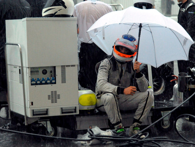 El piloto brasile&ntilde;o de F&oacute;rmula 1 Rubens Barrichello, de la escuder&iacute;a Brawn GP, se protege de la lluvia en el pit del equipo

Foto: Efe