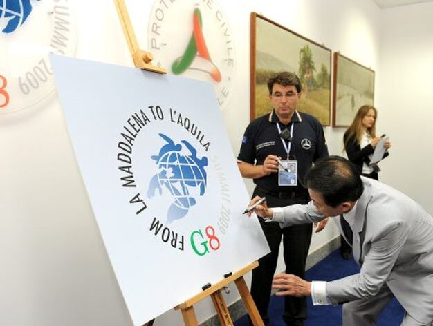 El primer ministro japon&eacute;s, Taro Aso, firma un cartel con el logotipo del G8 de L'Aquila.

Foto: EFE