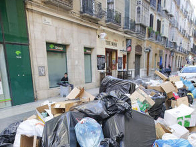 La calle Duque de la Victoria, con las bocas de los contenedores enterradas en basura.

Foto: Javier Albi&ntilde;ana