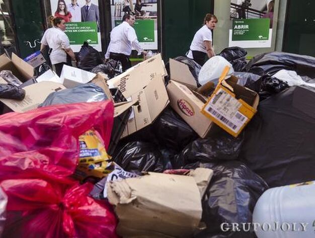 Varios trabajadores de un restaurante trasladan unas bolsas de basura hacia el contenedor.

Foto: Javier Albi&ntilde;ana