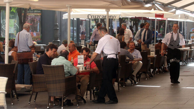 Un camarero atiende a unos turistas en una terraza de la capital.