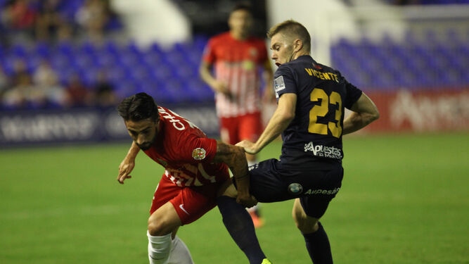 El centrocampista del UCAM, Vicente, trata de frenar la incursión de Chuli, jugador del Almería.
