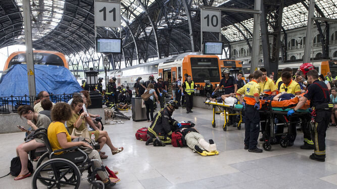Equipos de emergencia atendían ayer a los pasajeros heridos en el accidente en la estación de Francia de Barcelona.