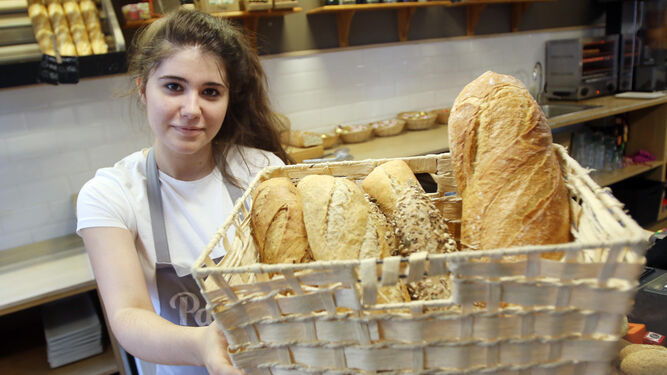 Una de las empleadas de la Cafetería Panaria muestra algunas variedades de pan que ofrece este establecimiento.