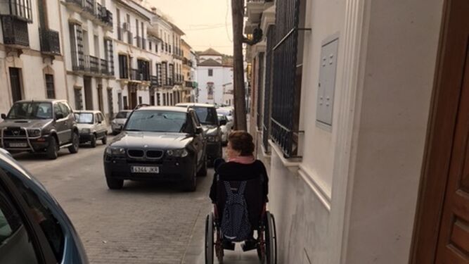 Una mujer en silla de ruedas, en el nuevo acerado.