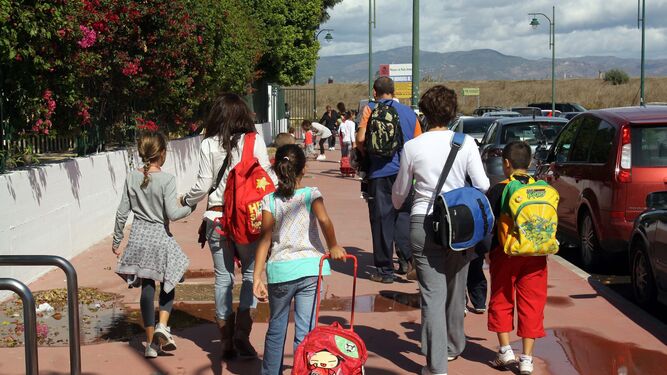 Un grupo de padres lleva a sus hijos al colegio.