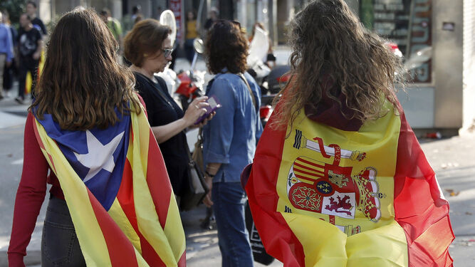 Dos universitarias envueltas  con la bandera estelada y con la española.