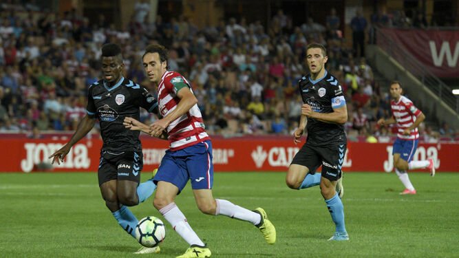 El centrocampista Azeez intenta cortar el avance de Raúl Baena (Granada), durante el partido del pasado domingo.