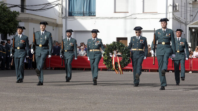 Varios guardias civiles portan una corona de laurel para ofrecerla a los compañeros caídos.