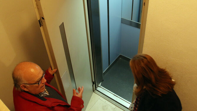 Un hombre invita a una mujer a pasar a un ascensor