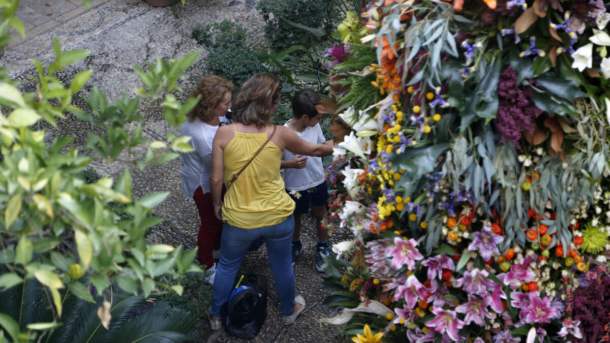 Una familia observa la intervención de Flores Cosmos, en el patio del Archivo Municipal.
