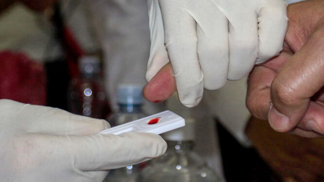 Un sanitario realiza una prueba rápida de VIH a un paciente.